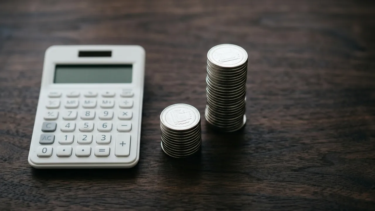 A white calculator with a blank display and two neat stacks of silver coins side by side— one tall — Sleeve vs bypass: cost compared